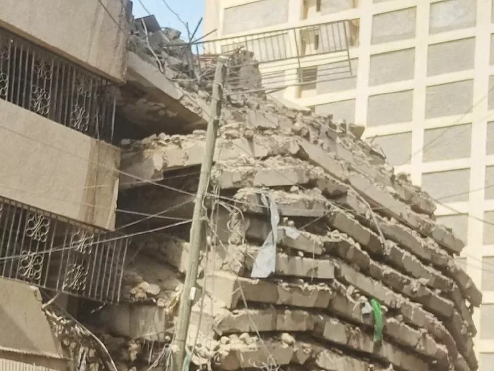 Floors of the collapsed building piled on top of each other beside neighbouring buildings in Eastleigh