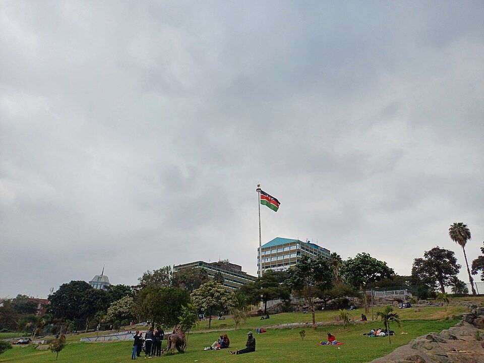 The Kenyan flag flies over government buildings, seen from Uhuru Park, Nairobi