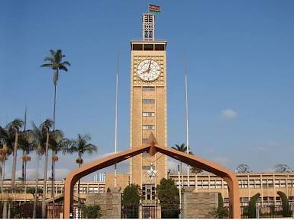 The clock tower and arched gate of Parliament Buildings, Nairobi, under a blue sky