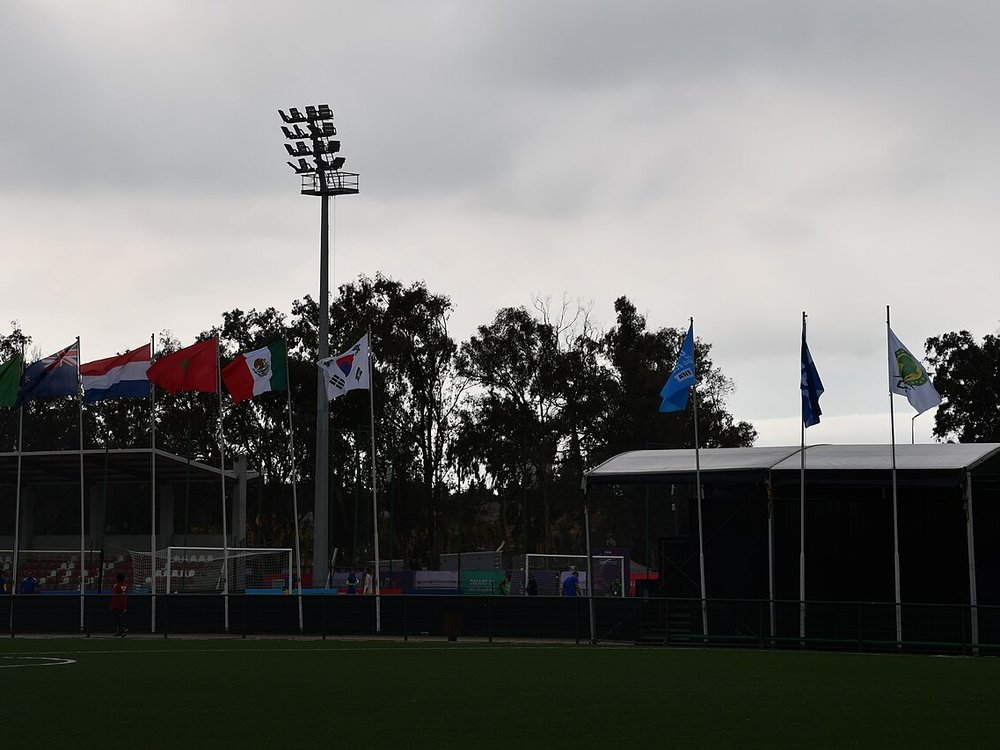 Flags and a floodlight beside a football pitch at the Mohammed VI Football Academy