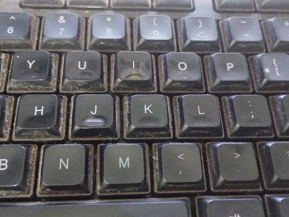 Close-up of the keys of a dusty black computer keyboard
