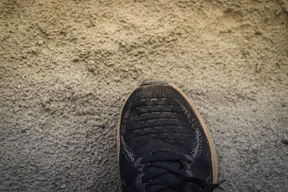 A running shoe on sandy ground. Illustration