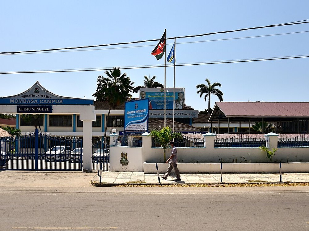 The gate of Kenyatta University's Mombasa campus, with Kenyan flags above it