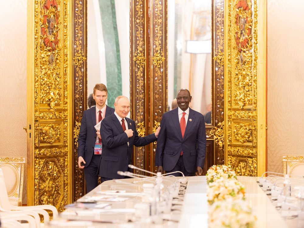 President Vladimir Putin, with a hand on President William Ruto's shoulder, entering a gilded hall at the Kremlin