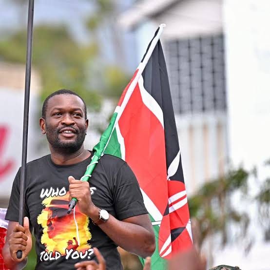 Senator Edwin Sifuna holding a Kenyan flag at a rally