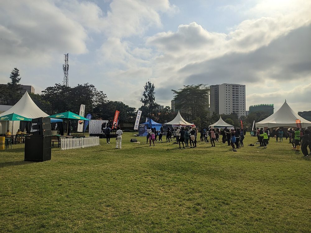 Runners warming up on a field beside white event tents in Nairobi